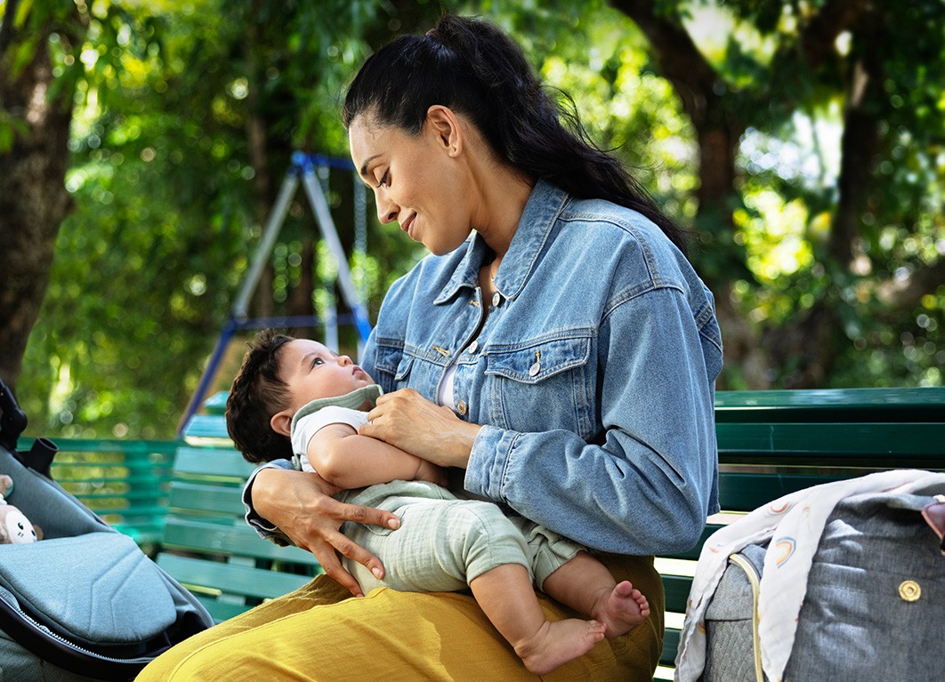 Woman holding baby on bench
