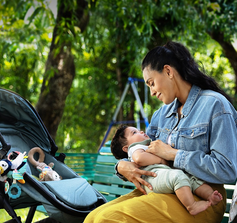 Woman holding baby on bench