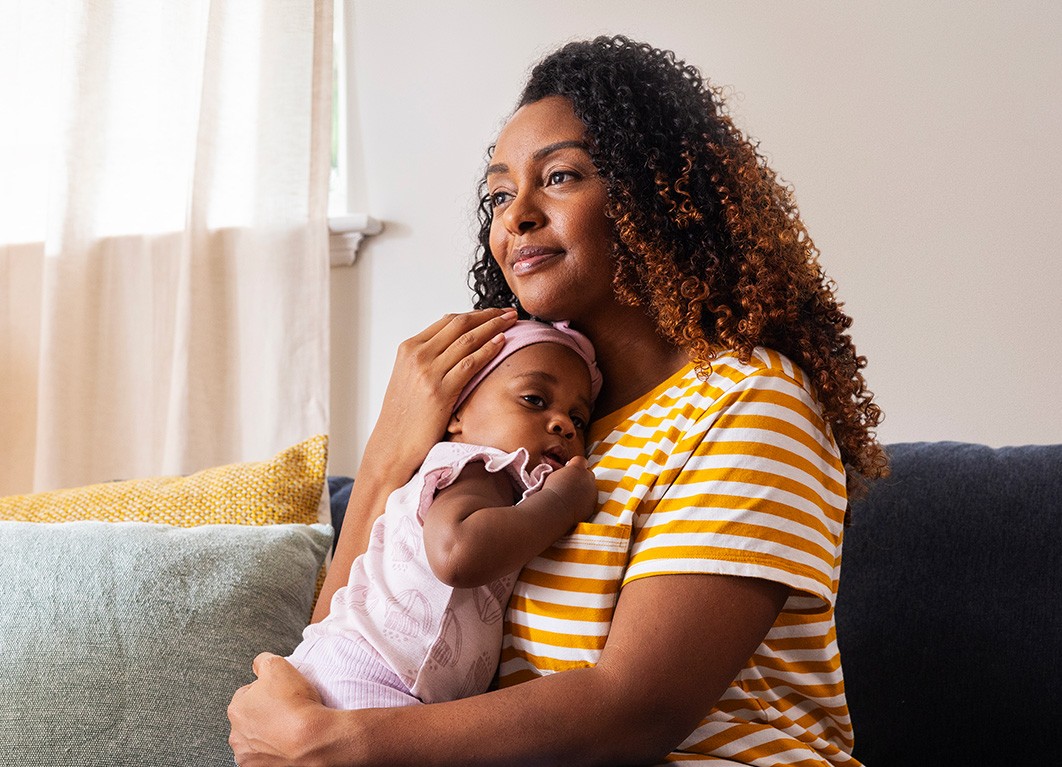Woman in a bedroom with her baby
