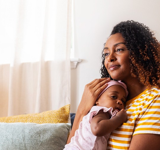 Woman in a bedroom with her baby