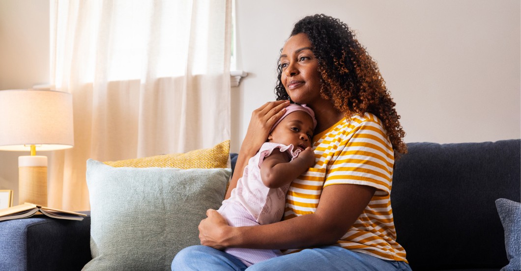 Woman sitting on bed reading to baby